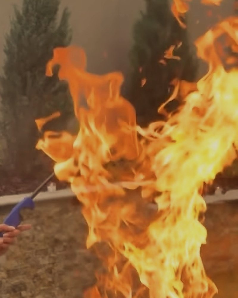 Tall flames rising off a hibachi grill during a private fire show